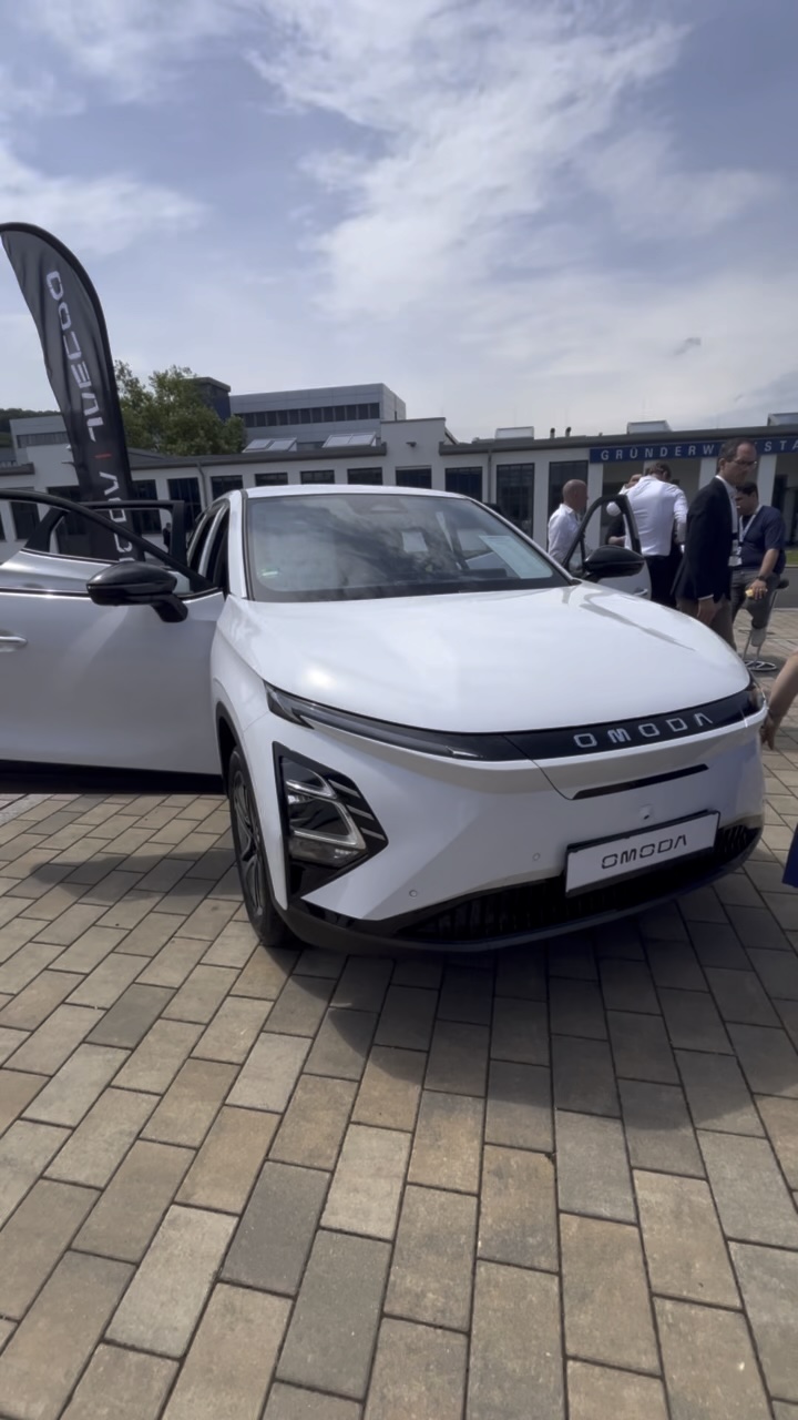 Weißes E-Auto OMODA vor Gebäude. Richter & Zech / Electric Horses erhielt Automotive Business Award 2024.